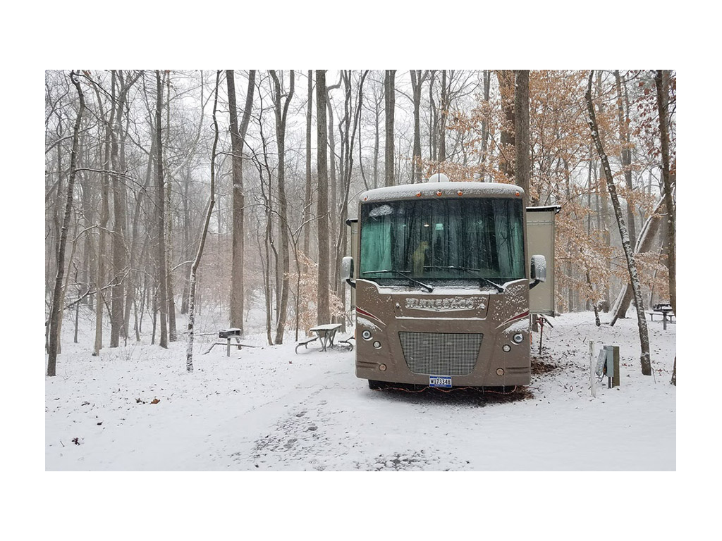 Winnebago Vista parked at snowy campsite