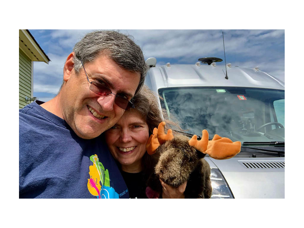 Daniel and Faith smiling holding stuffed Moose toy in front of Travato