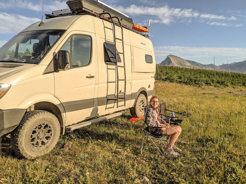 Kelly sitting in lawn chair next to Revel in grass