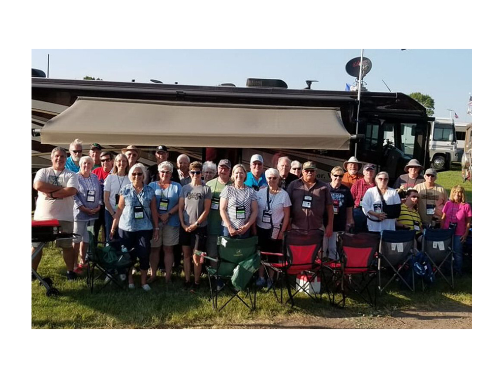 Large group standing in front of Winnebago Forza at Grand National Rally