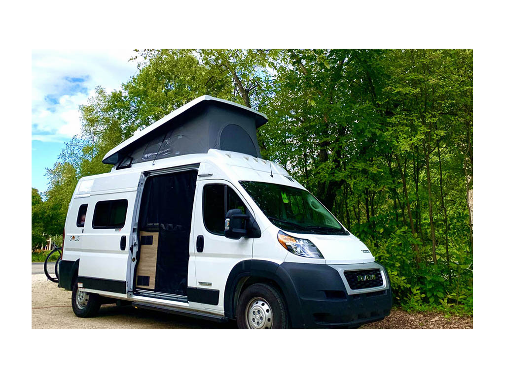 Winnebago Solis parked near trees with pop-top up