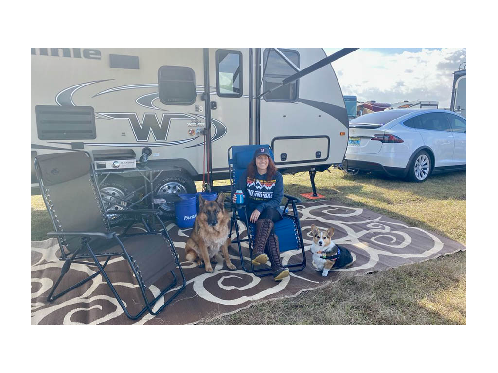 Becca sitting next to two dogs outside of Micro Minnie