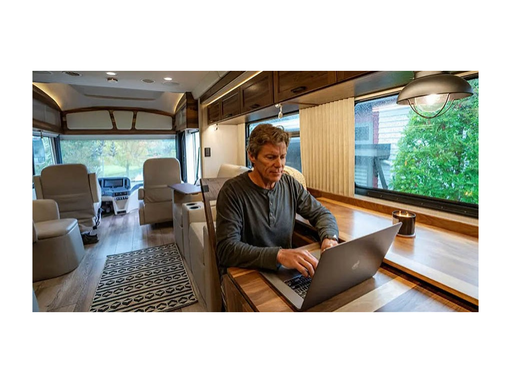 Adult person sitting at desk in Journey working on laptop