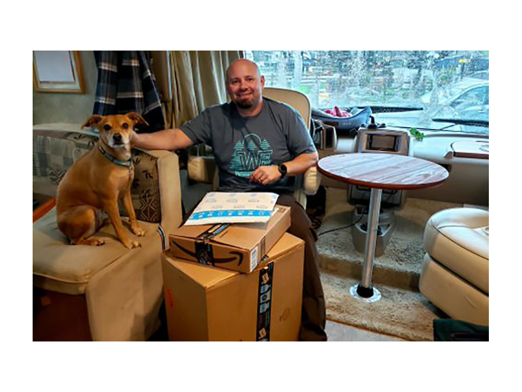 Kenny and Bella sitting inside Vista near a stack of Amazon packages