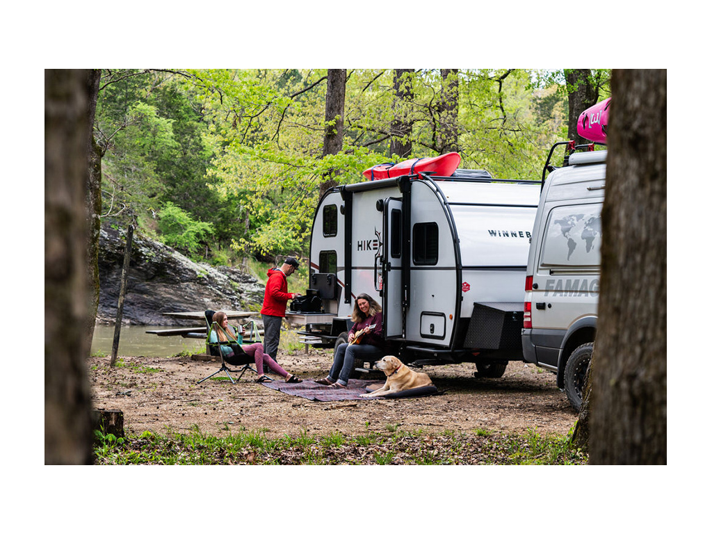 Holcombe family sitting outside of their Winnebago Hike with their dog Tucker