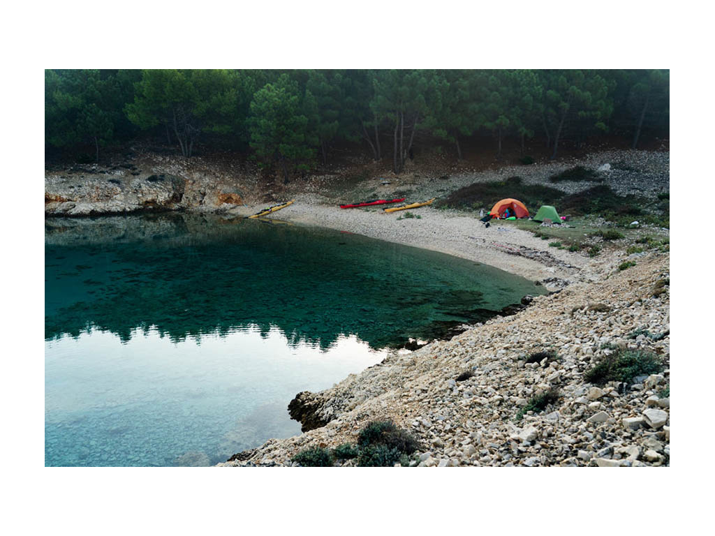 Two tents setup next to water at campsite