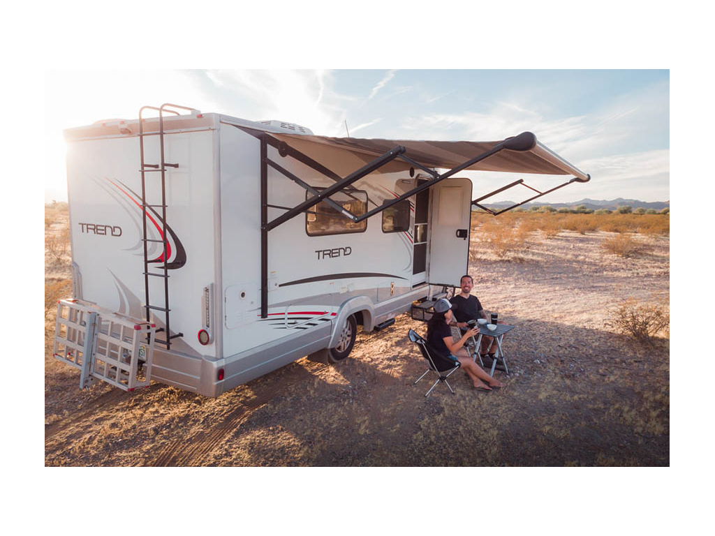 Nadia and Jon sitting outside of Trend next to small table drinking coffee