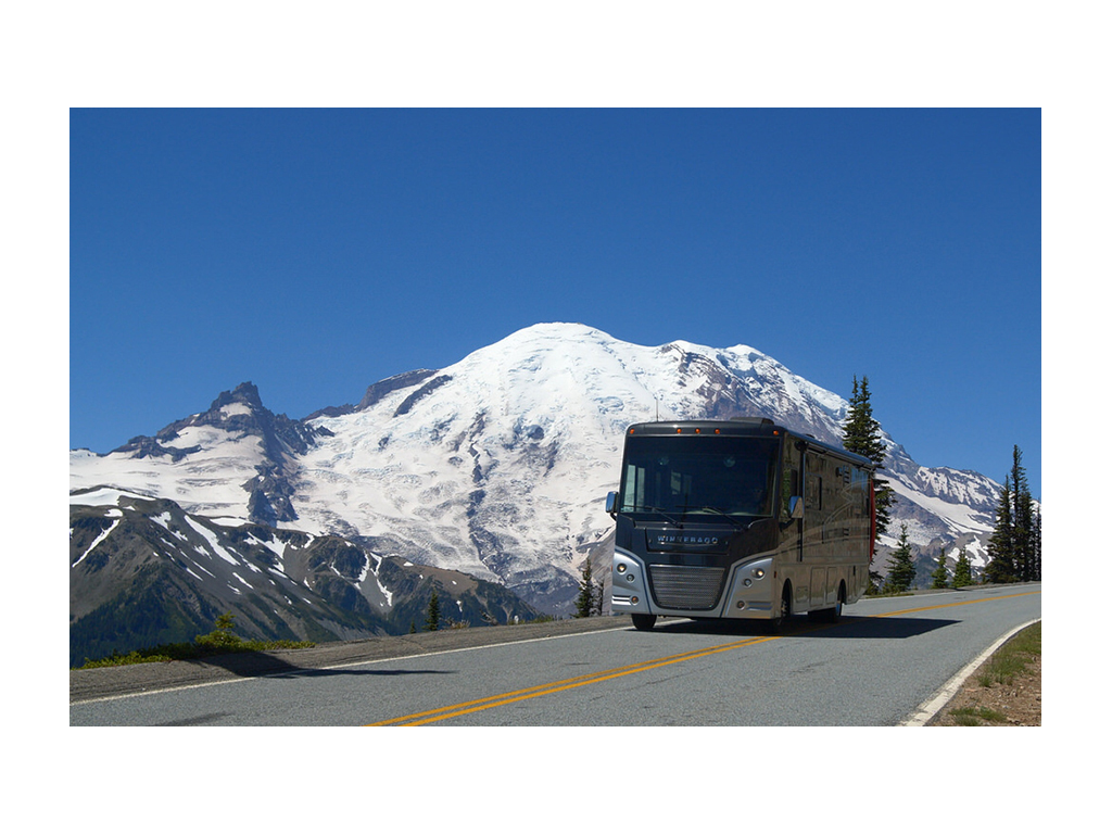 Winnebago Adventurer driving down road in Mount Rainer National Park