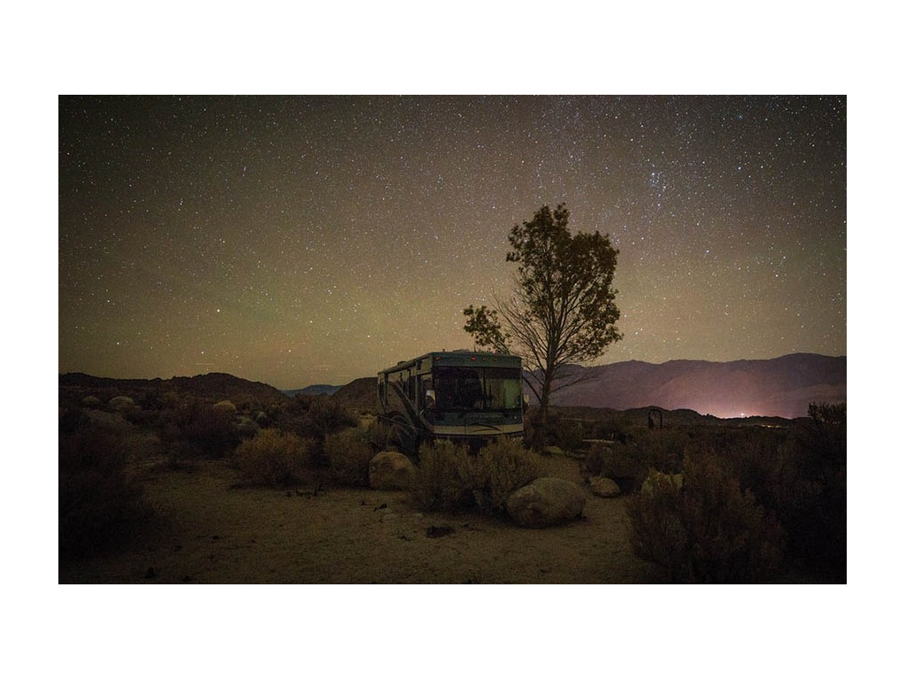 Night shot of Journey parked in Desert with starry sky in background