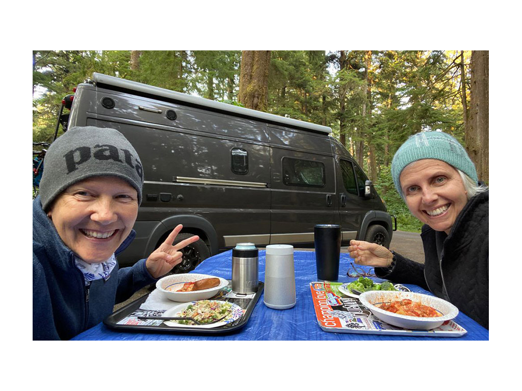 Noel and Chris eating at picnic table outside of Travato