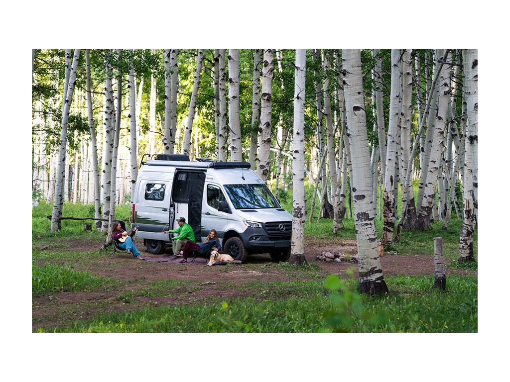 Abby, Peter, Kathy and yellow lab, Tucker, sitting outside of Revel with sliding door open.