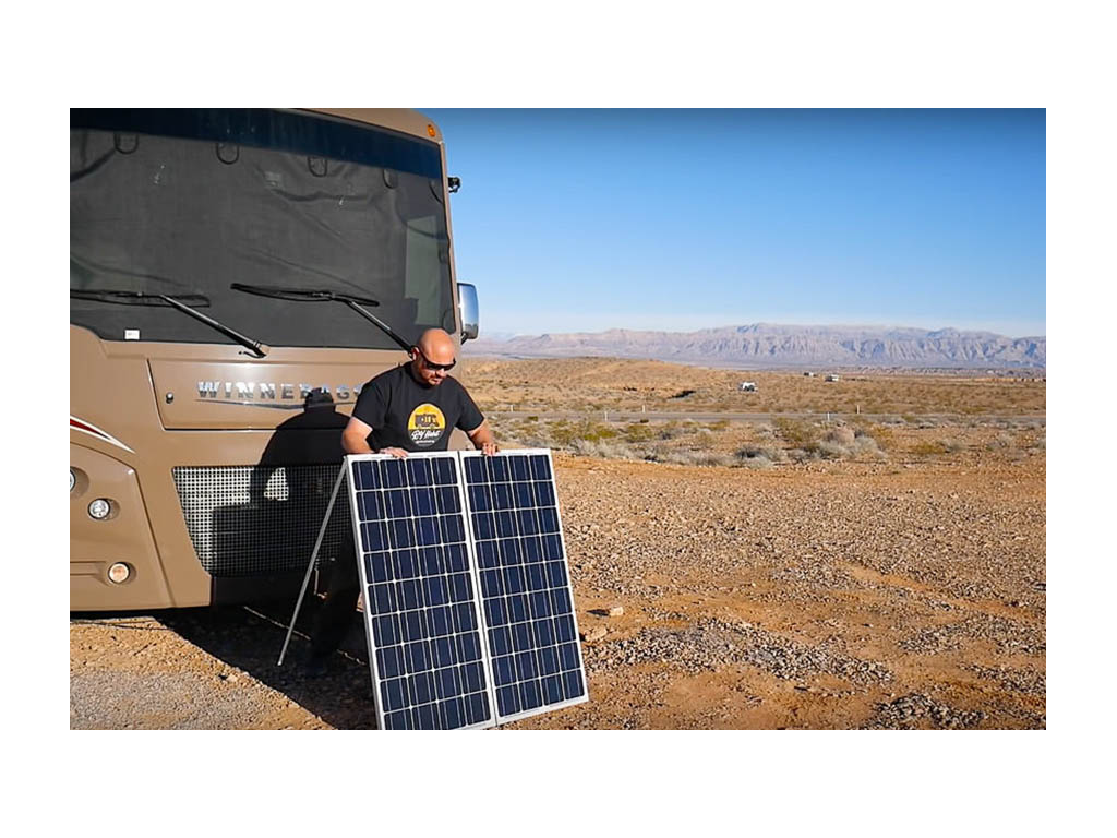 Kenny setting up portable solar panels in front of Vista