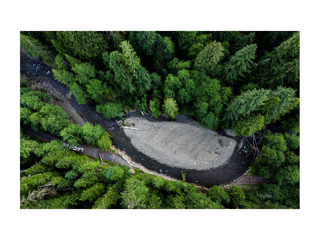 Aerial shot of View driving down road blocked by log
