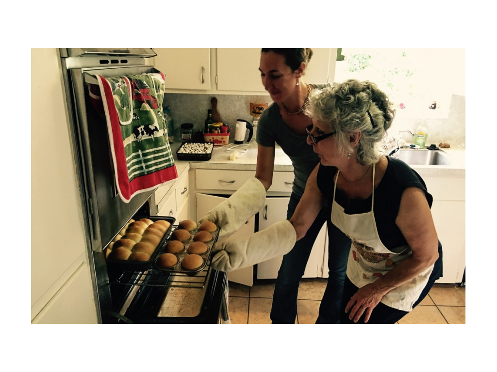 Brittany and her mom taking rolls out of oven