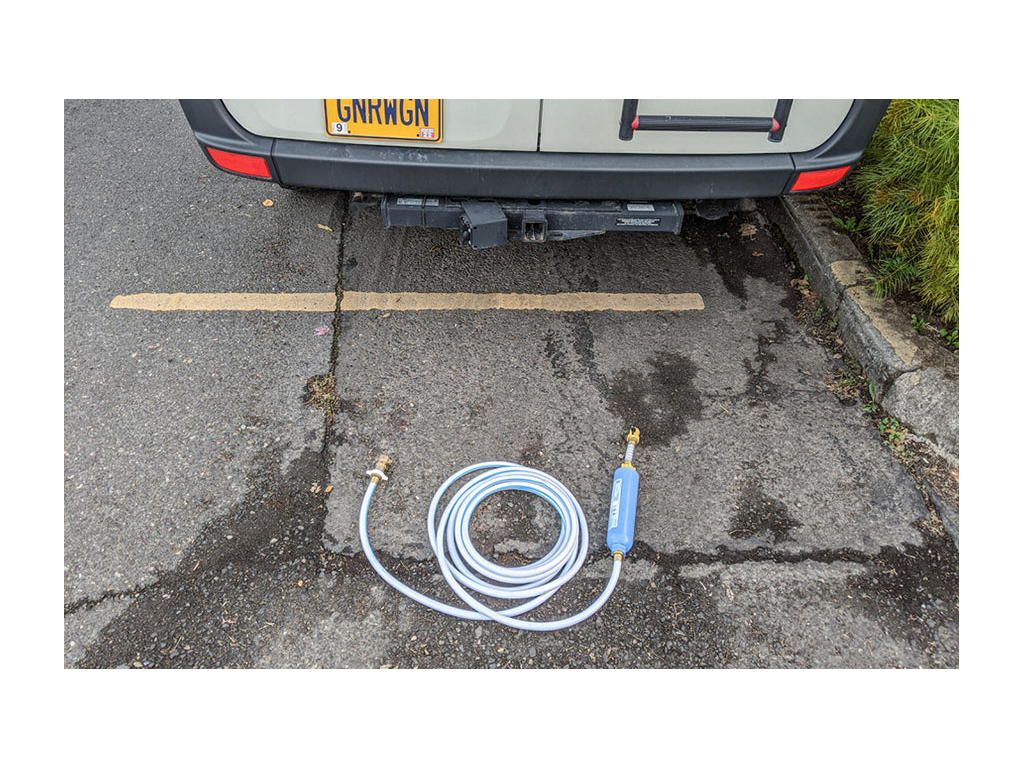 Gnar Wagon parked on road with water hose laying on ground behind it