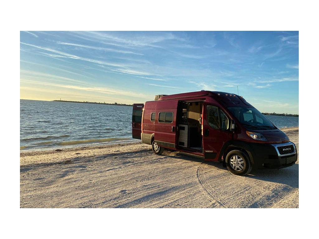 Solis parked on beach with back and side doors open