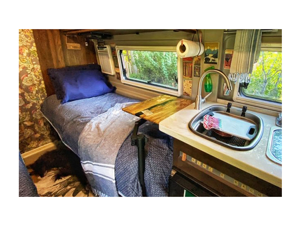 Wooden desk in Travato over driver side bed