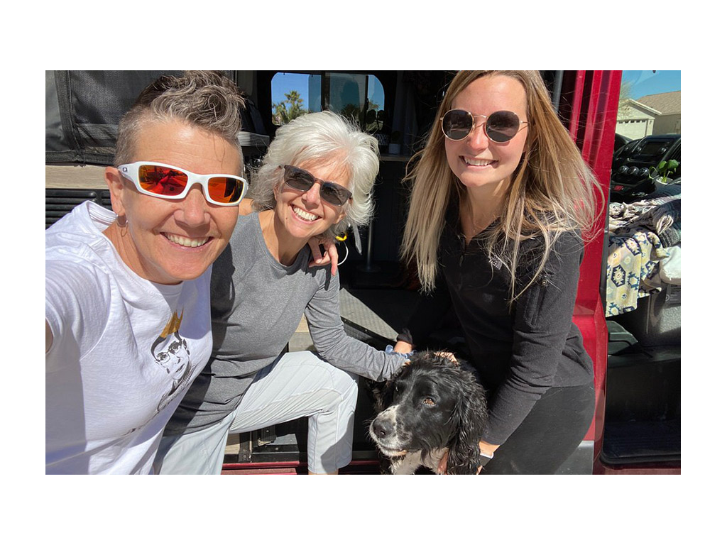 Noel and Chris smiling with a friend and dog in front of Solis