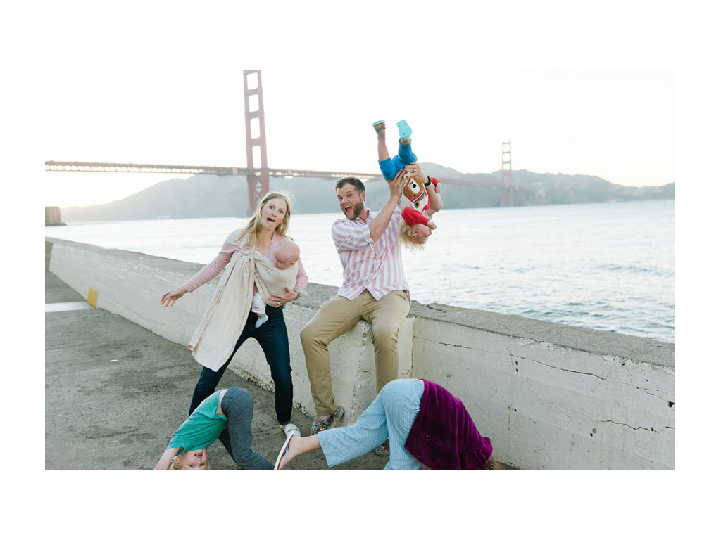 Wages family posing for a funny photo in front of bridge over water