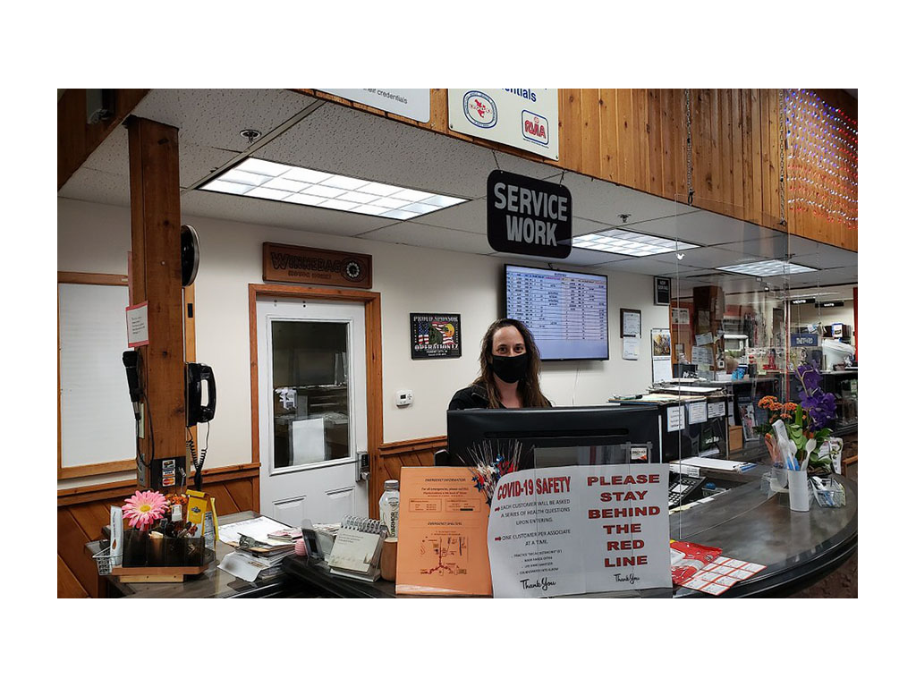 Winnebago employee wearing mask standing behind front desk