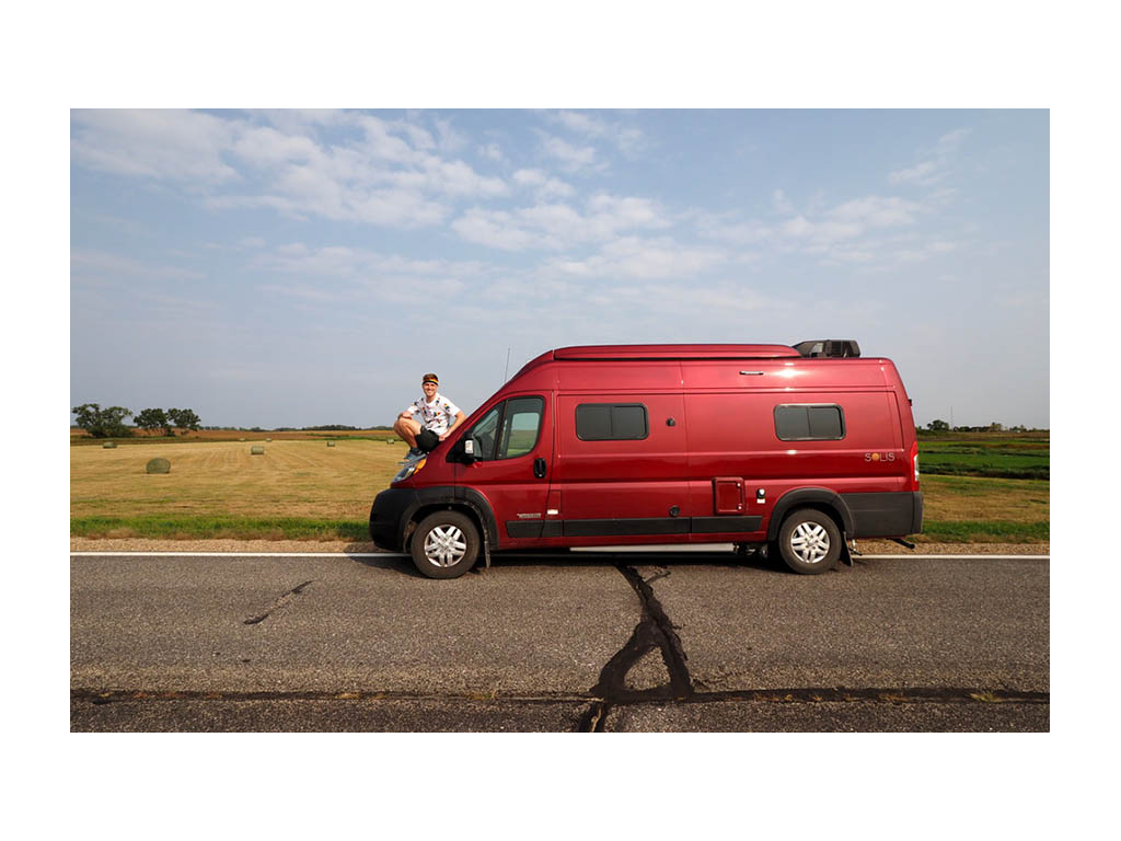 Mikah sitting on hood of Solis smiling