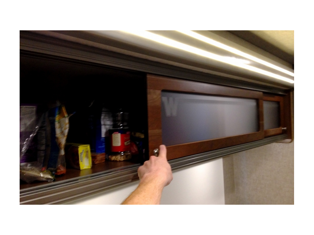 Upper cabinets that slid open to reveal food storage.