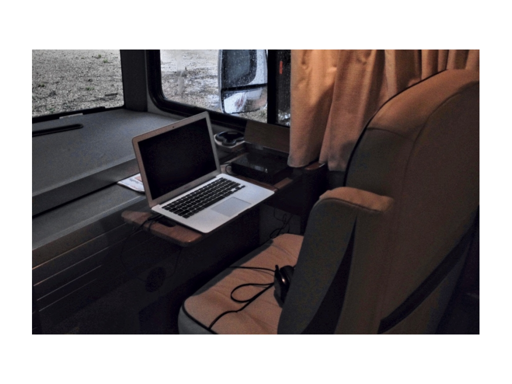 Tray with a laptop on it in front of the passenger seat.