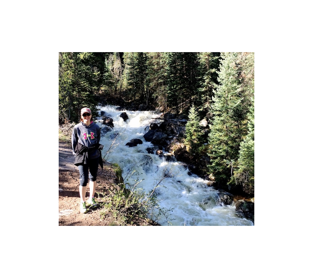 Kelli Harms standing next to a rushing creek.