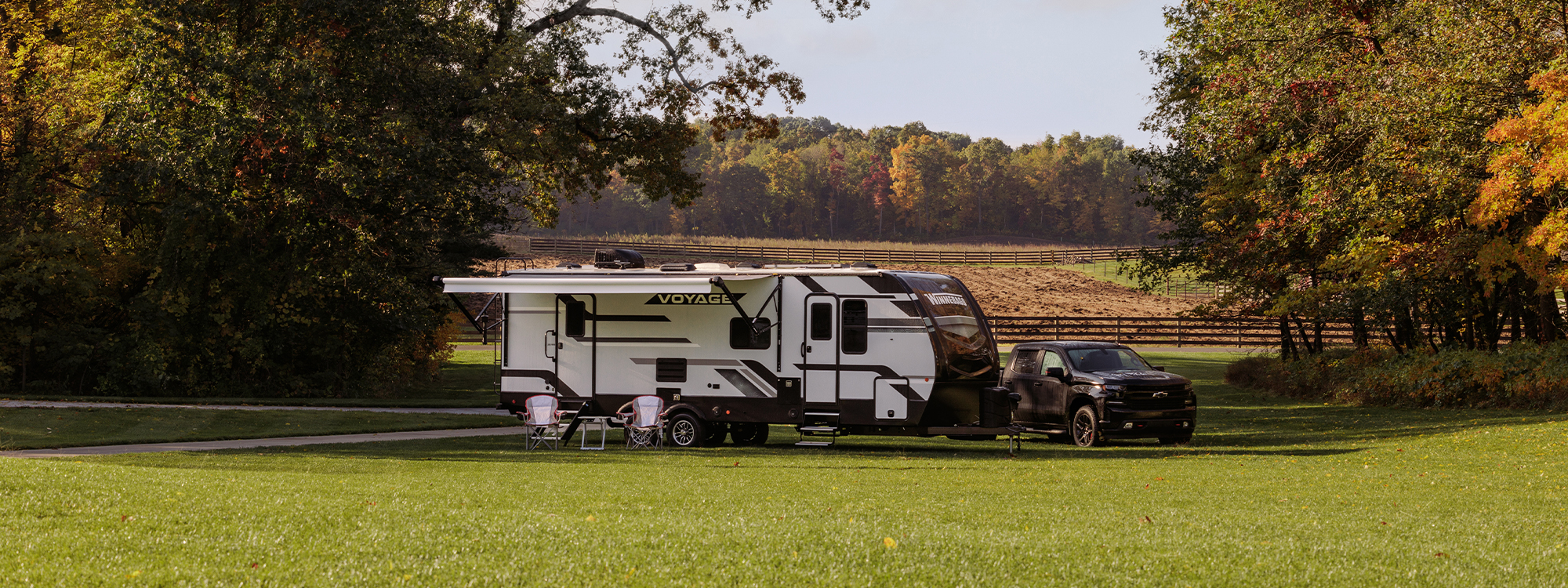 voyage travel trailer parked in an open field