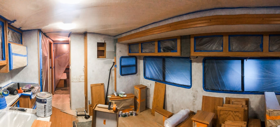 Living room mid-renovation with trim taped off for painting