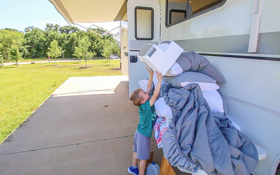 Young boy removes items from the RV for RV spring cleaning
