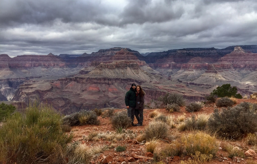 Couple standing at the edge of the Grand Canyon.