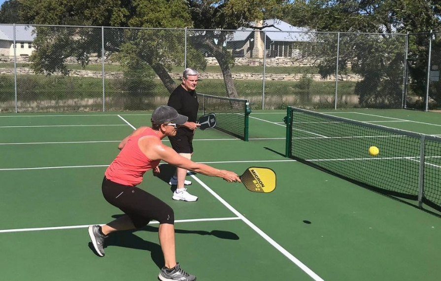 Lin returning pickleball to other side of the court