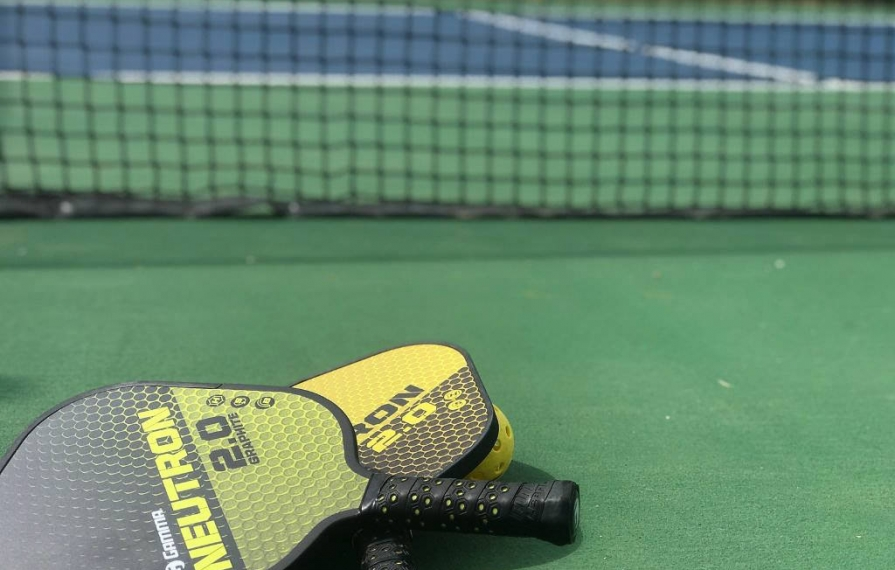 Two paddles stacked on a pickleball court