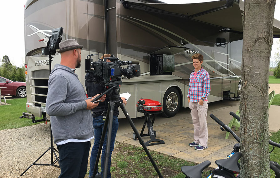 Ann standing next to Forza being filmed for television show