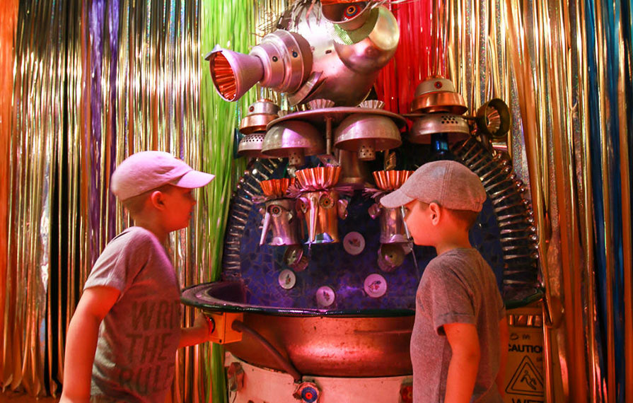 The boys looking at a fun machine at the Kaleidoscope