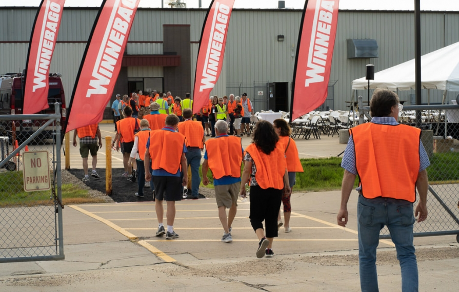 Winnie Bs wearing orange vests ready to tour of Winnebago Manufacturing Facility in Charles City