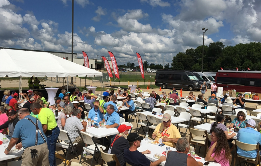 Winnie Bs and Winnebago employees eating lunch at tables outside