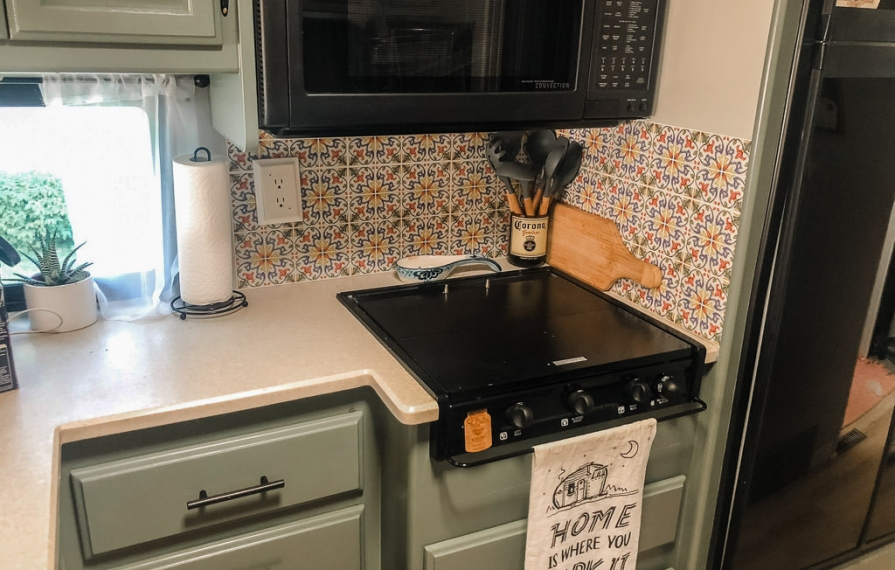 Green cabinets and light colored counter tops in finished kitchen.