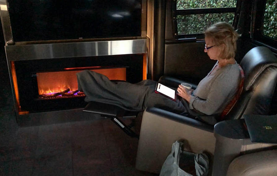 Terry sitting in front of Horizon fireplace drinking coffee