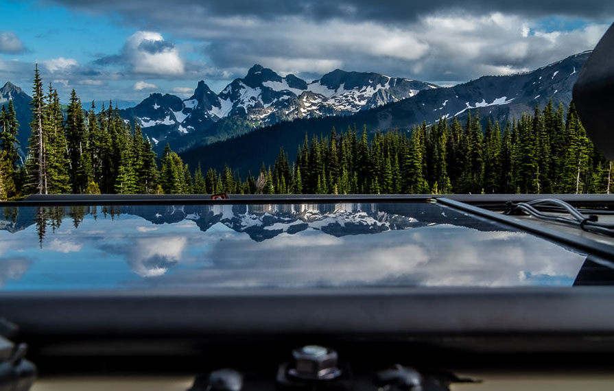 View from top of the Winnebago Adventurer with solar panels and mountains in the background