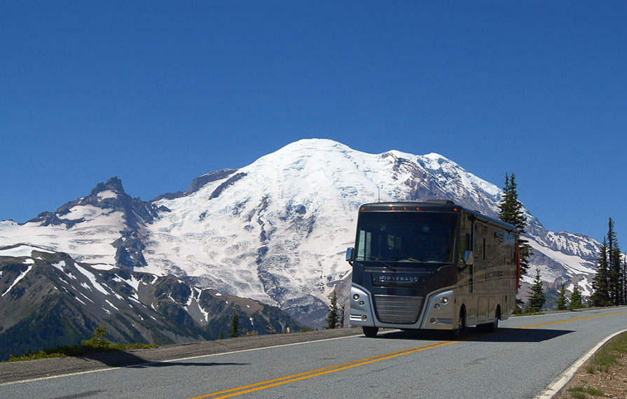 Winnebago Adventurer driving with mountains in the background