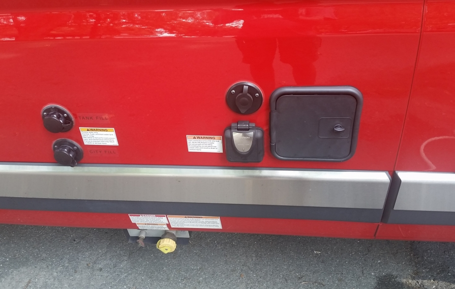 Water hook up and sewer hose compartment on exterior of motorhome.