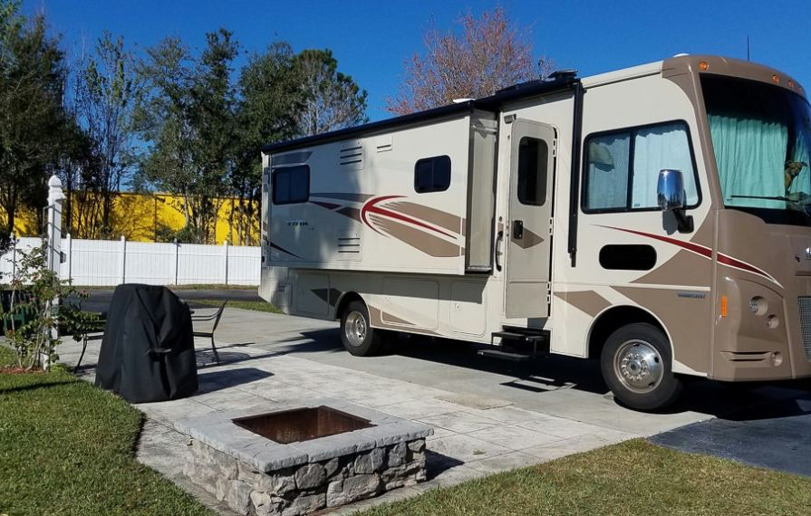 Winnebago Vista LX at a campsite with a fire pit and picnic table.