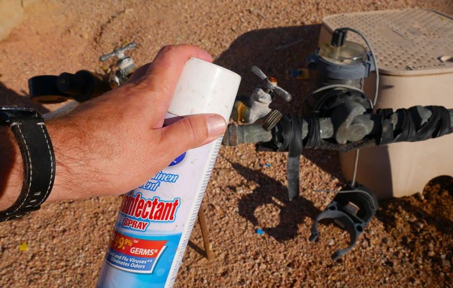 Using disinfectant spray to clean water nozzle.