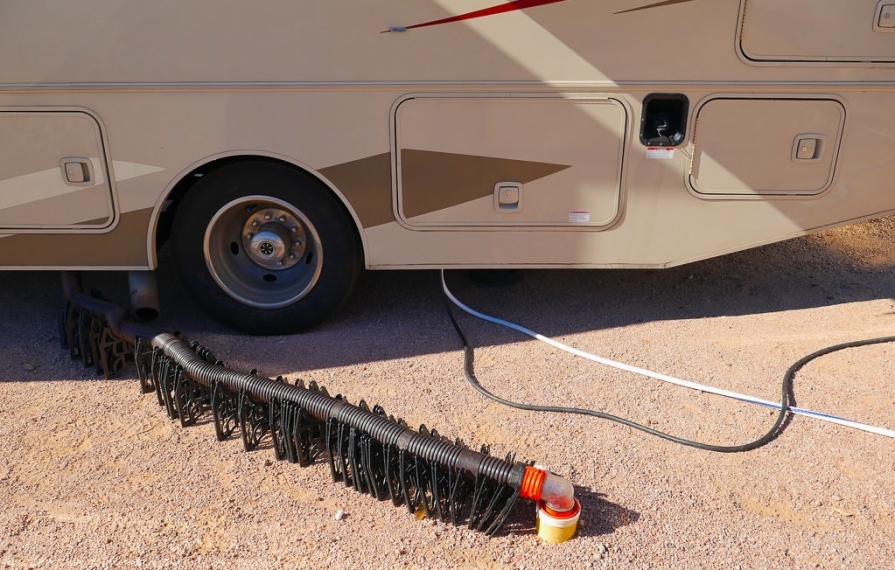 Sewer hose support guiding hose from motorhome to dump site.