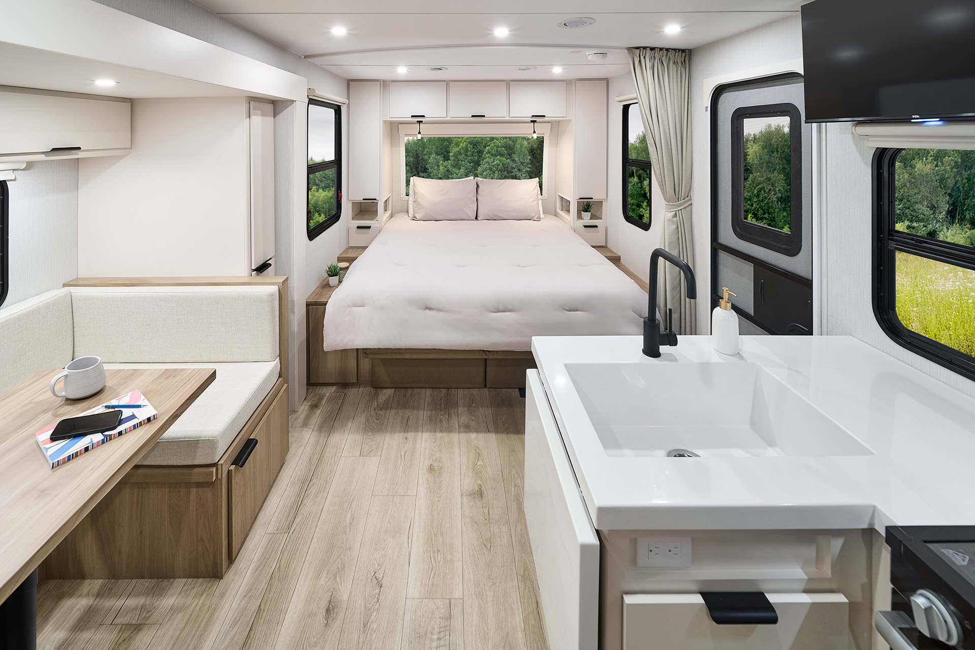 2026 Winnebago Thrive 22MBH — Back to front interior view of Thrive 22MBH travel trailer with galley, dinette, bed, and entry