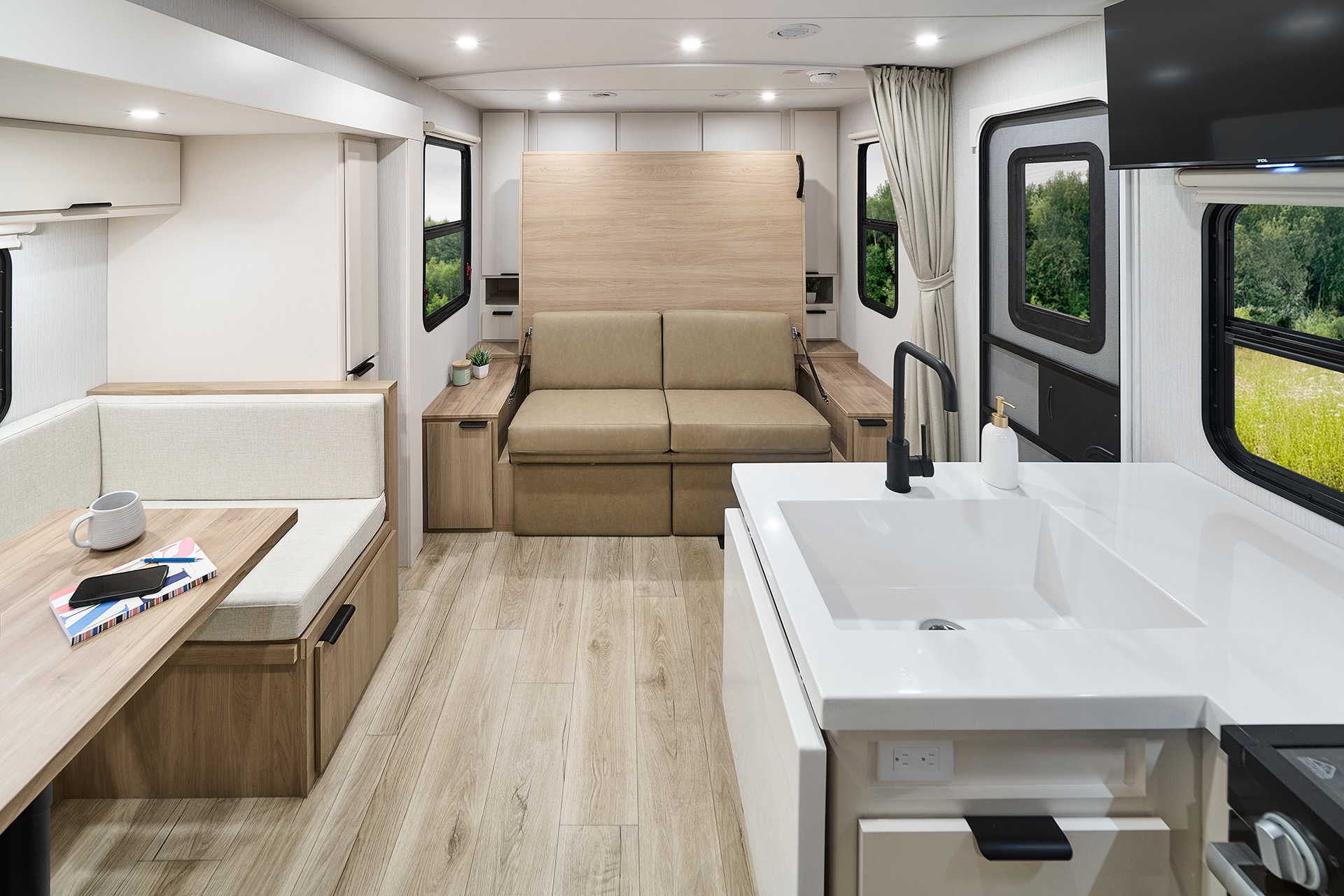 2026 Winnebago Thrive 22MBH — Back to front interior view of Thrive 22MBH travel trailer with galley, dinette, Murphy bed, and entry