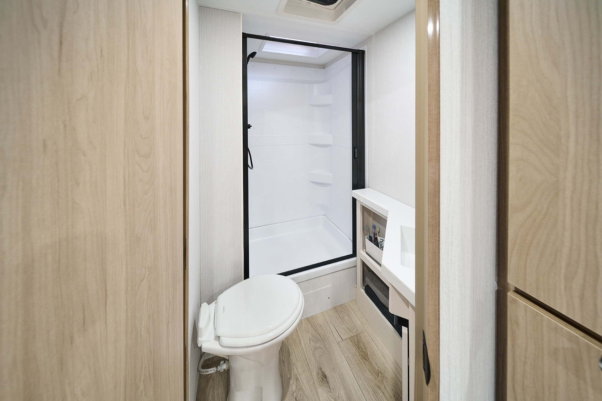 2026 Winnebago Thrive 22MBH — Close up of bath inside a Winnebago Thrive 22MBH, including a cassette toilet and shower