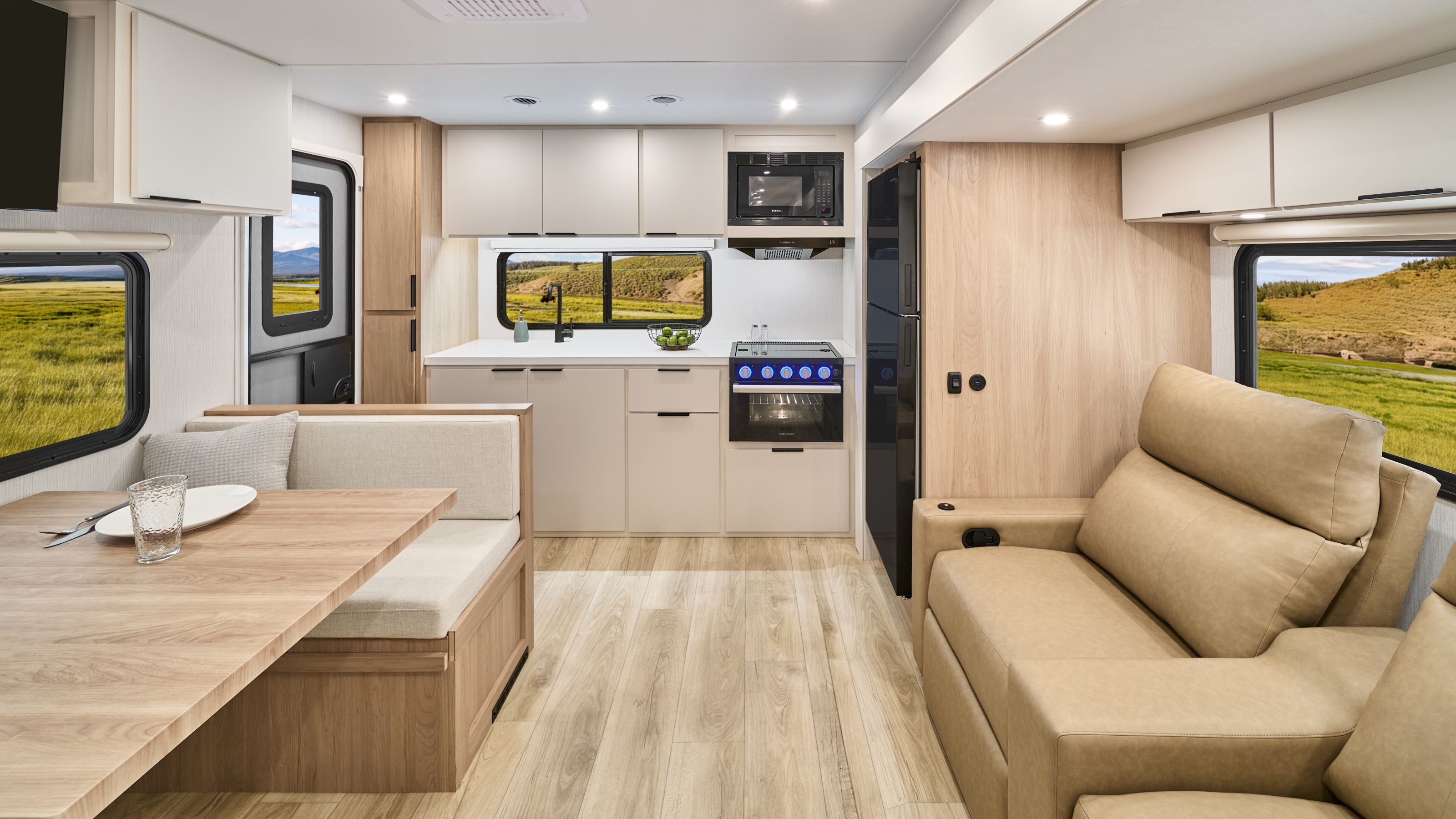 2026 Winnebago Thrive 24RKS — Interior of Thrive 24RKS, showing a dinette, lounge seating, and a galley.